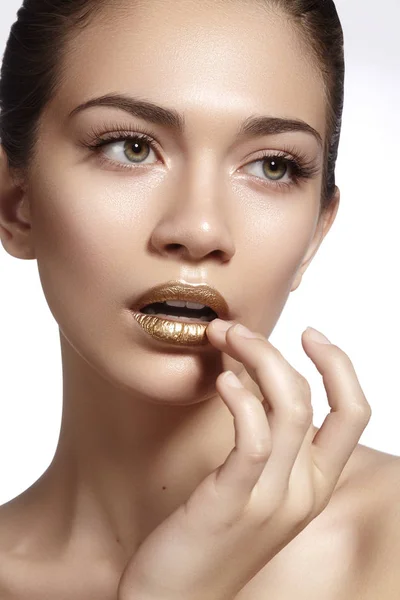 Junge schöne Frau mit sauberer weicher Haut, goldenen Lippen Make-up. perfekte Augenbrauen Formen. Tagesschminke — Stockfoto