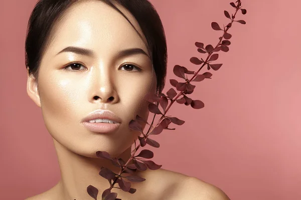 Beautiful asian woman with fresh daily makeup. Vietnamese beauty girl in spa treatment with green leafs near face — Stock Photo, Image