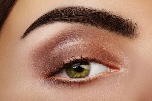 Close-up schoonheid van de vrouw de ogen. Sexy rokerige ogen make-up met bruine Eyeshadows. Perfecte sterke vorm van wenkbrauwen — Stockfoto