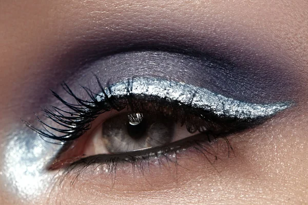 Schöne Makroaufnahme des weiblichen Auges mit zeremoniellem Make-up. perfekte Form von Augenbrauen, Eyeliner und Silberstreifen auf dem Augenlid — Stockfoto