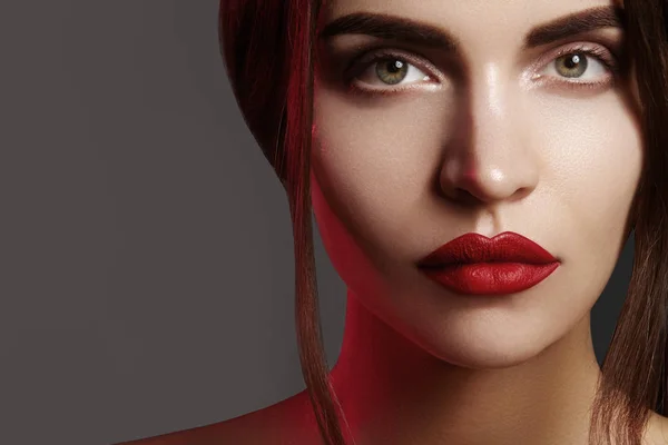 Nahaufnahme Porträt mit einem schönen Frauengesicht. rote Farbe der Mode Lippen Make-up, saubere, glänzende Haut und starke Augenbrauen — Stockfoto