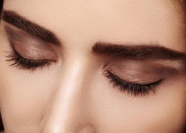 Perfect shape of eyebrows, brown eyeshadows and long eyelashes. Closeup macro shot of fashion smoky eyes visage — Stock Photo, Image