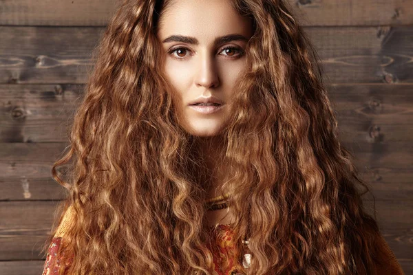 Uzun kıvırcık saç modeli, moda takı esmer saçlı güzel genç kadın. Hint tarzı kıyafetler, uzun elbise