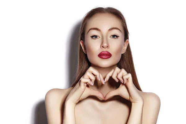 Mujer joven romántica haciendo forma de corazón con sus dedos. Símbolo de amor y San Valentín. Chica de moda con sonrisa feliz — Foto de Stock