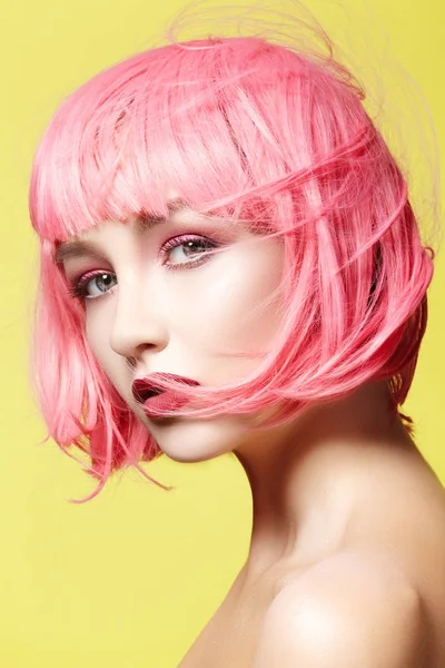 Mujer joven con peluca rosa. Hermosa modelo con maquillaje de moda. Mirada brillante de primavera. Color de pelo sexy, peinado medio —  Fotos de Stock