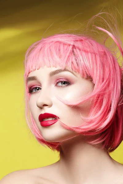 Young woman in pink wig. Beautiful model with fashion makeup. Bright spring look. Sexy hair color, medium hairstyle
