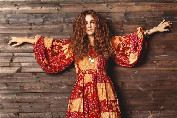 Belle jeune femme avec longue coiffure bouclée, bijoux de mode avec cheveux bruns. Vêtements de style indien, robe longue — Photo