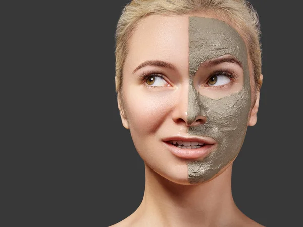 Beautiful Woman Applying Facial Mask. Beauty Treatments. Spa Girl Apply Clay Facial Mask on Grey Background. Funny Face — Stock Photo, Image