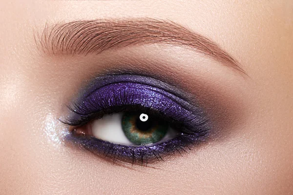Closeup Macro of Woman Face with Purple Eyes Makeup. Fashion Celebrate Makeup, Glowy Clean Skin, perfect Shapes of Brows