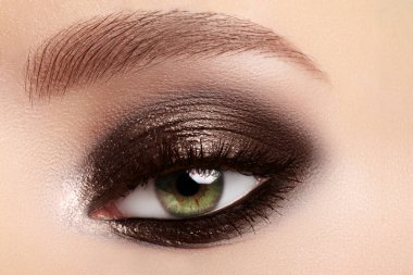 Beauty, cosmetics and makeup. Elegant classical smoky make-up on female eyes. Beauty, cosmetics and makeup. Dark brown eyeshadow make-up, glamour evening style clipart