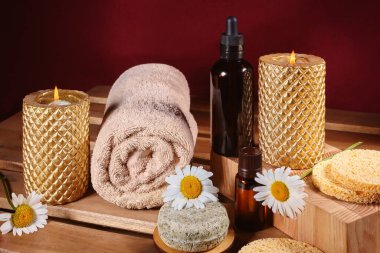 Güzel bir spa kompozisyonu. Bitkisel yağ, doğal sabun ve altın mumlarla yapılan Aromaterapi. Tahta Arkaplanda Gevşeme Rengi ve Isınma Havluları