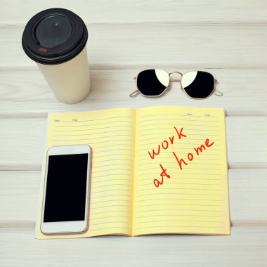 Evde çalış. Akıllı Telefon, Not ve Sabah Kahvesi ile Mükemmel Minimal Çalışma Masası. Ofis Freelancer Masası. Gerekli aksesuarlarla Şık Çalışma Yeri