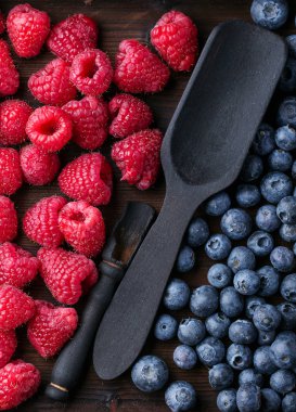 Blueberrys ve raspberrys rustik ahşap tahta üzerinde
