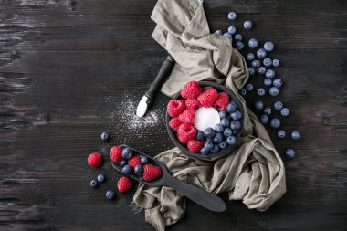 Blueberrys ve raspberrys rustik ahşap tahta üzerinde
