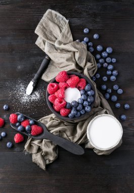 Blueberrys ve raspberrys rustik ahşap tahta üzerinde