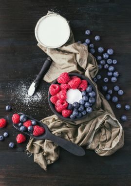 Blueberrys ve raspberrys rustik ahşap tahta üzerinde