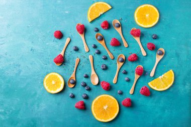 Blueberrys ve raspberrys mavi ahşap tahta üzerinde