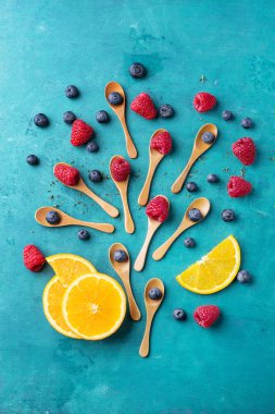 Blueberrys ve raspberrys mavi ahşap tahta üzerinde