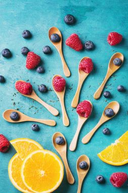 Blueberrys ve raspberrys mavi ahşap tahta üzerinde