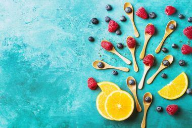 Blueberrys ve raspberrys mavi ahşap tahta üzerinde