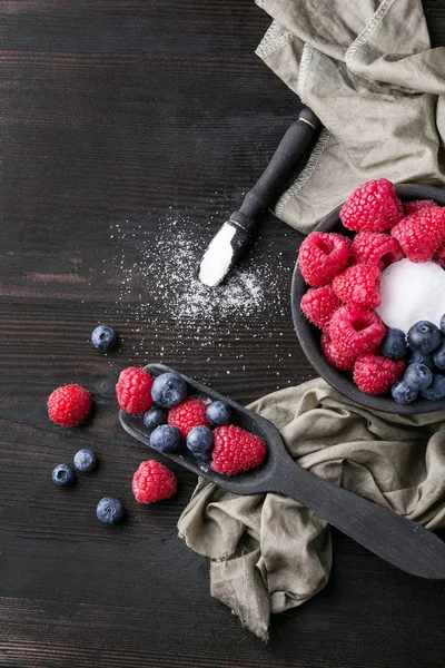 Blueberrys ve raspberrys rustik ahşap tahta üzerinde