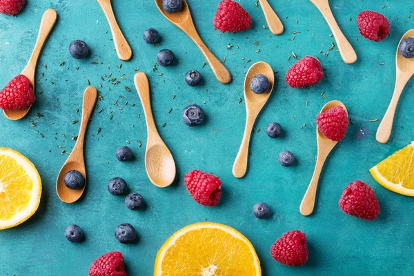 Blueberrys ve raspberrys mavi ahşap tahta üzerinde