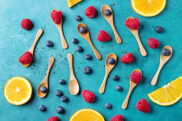 Blueberrys ve raspberrys mavi ahşap tahta üzerinde