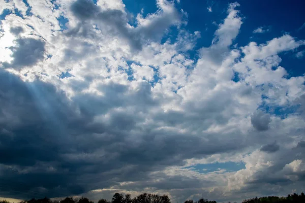 Schöner blauer Himmel mit Wolken und Sonnenstrahlen — Stockfoto