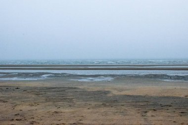 kum üzerinde arka planda insanlarla sisli gün