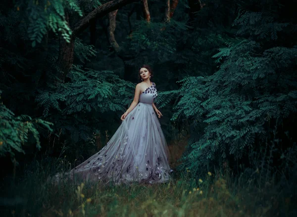 Belle fille dans une robe longue magnifique, marcher parmi les arbres  . — Photo