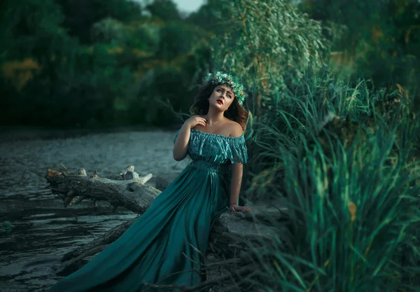 Bruxa de luxo em um vestido verde longo para o lago — Fotografia de Stock