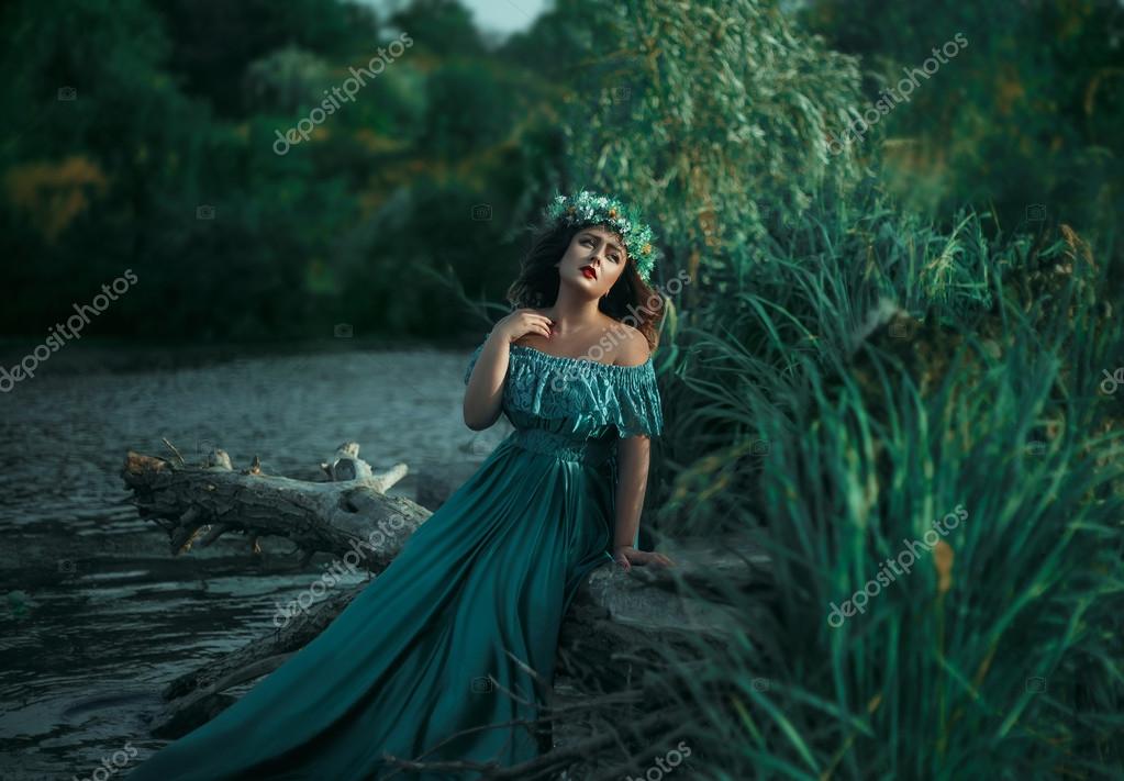 Luxury witch in a long green dress for lake Stock Photo by