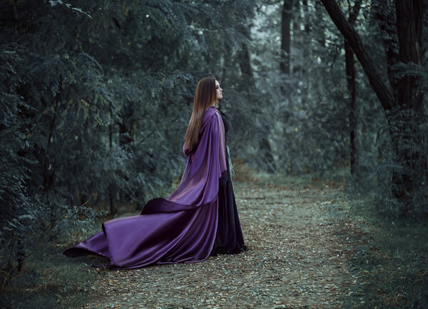 On the eve of Halloween witch casts a spell, decided to collect the potion to cook, walk in the mysterious forest. Fabulous and mystical concept. Fantastic shooting in the wild. Fashionable toning. Creative color.