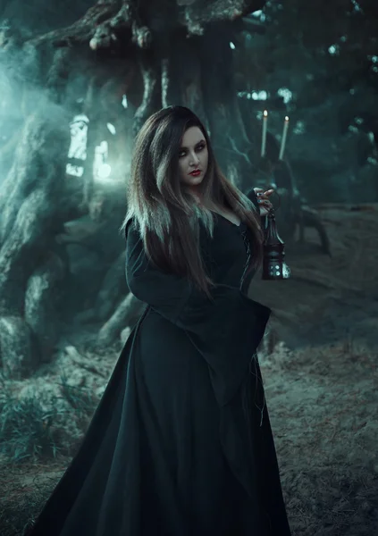 Wicked witch in a long vintage dress, holding a magic lamp . — Φωτογραφία Αρχείου