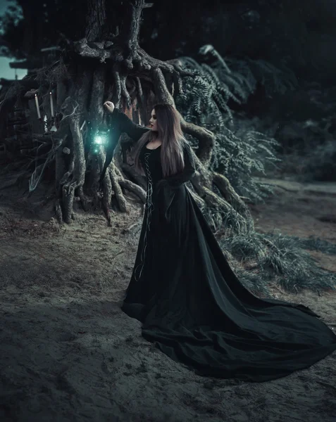 Злая ведьма в длинном винтажном платье, вызывает дух — стоковое фото