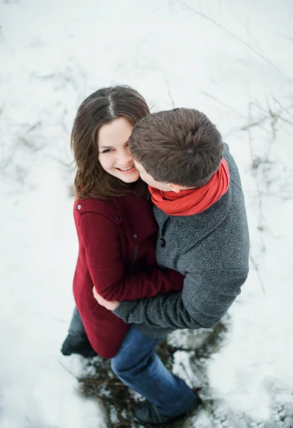 Attraktiva unga par i kärlek i den snötäckta parken — Stockfoto