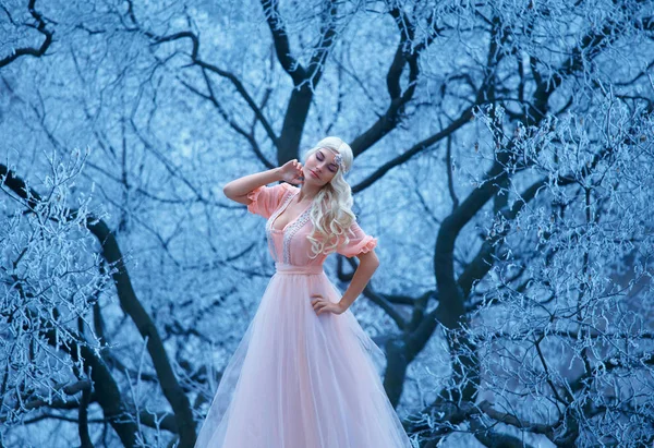 Mooi jong meisje staat in achtergrond besneeuwde bomen. — Stockfoto