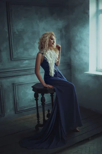 Une fille blonde dans une robe bleue luxueuse — Photo