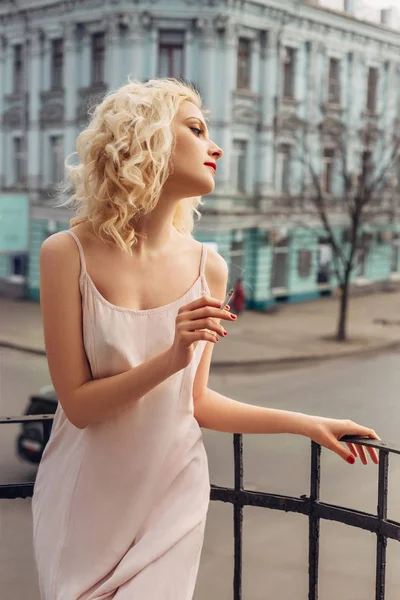 Blond dívka pózuje na balkóně — Stock fotografie