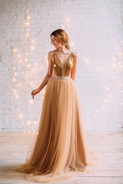 Брюнетка дівчина в розкішній золотій сукні — стокове фото