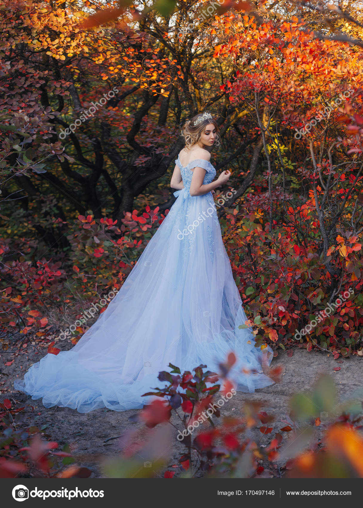 A young princess walks in a beautiful blue dress Stock Photo by