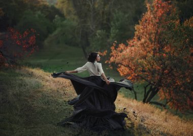 Vintage elbiseli bir kız gibi kül parçacıkları böler. Arka plan vahşi doğa. Sanatsal fotoğraf