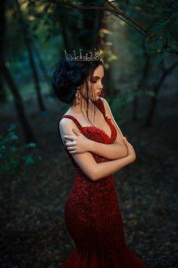 Kırmızı elbiseli çekici kız. Peri ormanda yürümek. Sanatsal fotoğraf