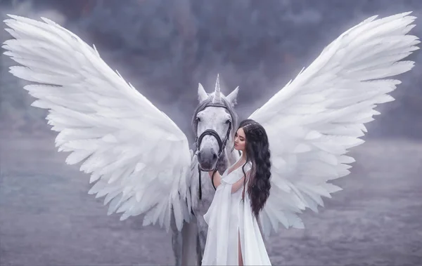 Hermoso, joven elfo, caminando con un unicornio. Lleva un vestido blanco y ligero increíble. Hotografía artística — Foto de Stock
