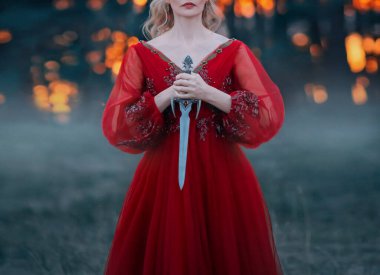 Esrarengiz sarışın bir kadın elinde güzel Gotik tasarımlı bir hançer tutuyor. Karanlık bir ormanda fantezi kadın asker moda savaşçısı. Yüzü ve elleri olmadan ateş etmek. Kafasını kes.