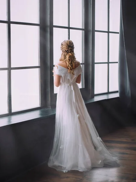 Femme blonde dans une vieille chambre sombre. Photographie d'art. Robe blanche, sans visage — Photo