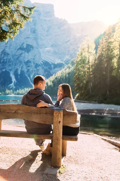 Aşıklar tahta bankta otururlar. Alp Gölü Braies doğanın tadını çıkarırlar. Erkek güzel kadın yüzüne dokunur. Kız usulca oğlanı kucaklıyor. Dinlenmeye bayılırım. Arka plan inanılmaz beyaz dağlar yeşil orman suyu