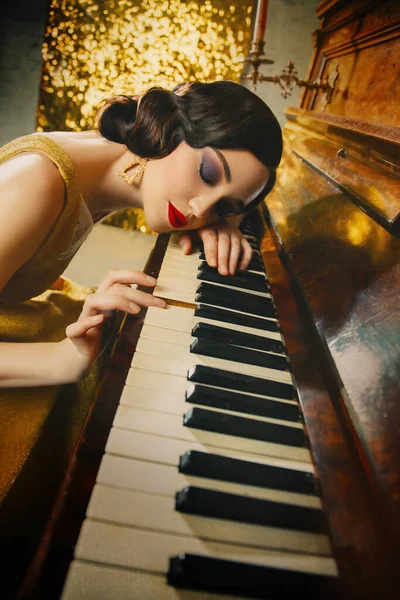 Närbild retro porträtt ung vacker Great Gatsby kvinna finger våg frisyr smokey katt ögon makeup röda läppar. musiker spelar piano melodi vidrör nycklar hennes hand guld klänning mode gammal stil 1920 — Stockfoto