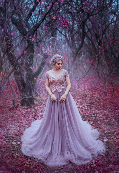 Woman queen walk in autumn deep magic forest leaves trees. Elegant blonde hair princess. hairstyle crown. Royal Medieval clothes. vintage evening purple full lush long dress. blue mystic gothic fog