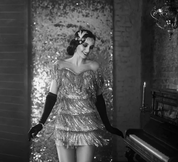 Fiatal boldog flapper gyönyörű nő. ujjhullám hajpánt. rövid szexi ezüst ruha, mosolygós arc. A modell táncol. háttér régi klasszikus belső tér. Fekete-fehér fotó. Stílus üvöltés Party 20-as évek — Stock Fotó